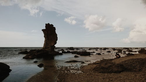 Scenic view of beach against cloudy sky