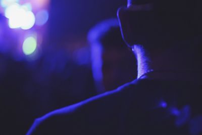 Rear view of man against illuminated lights