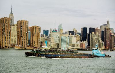 River by cityscape against sky