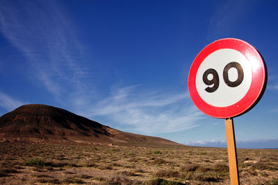 Road sign against blue sky