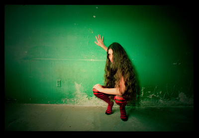 Side view of a woman sitting on floor