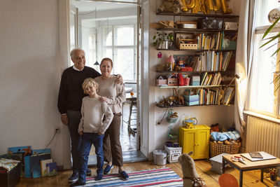 Portrait of happy grandparents with grandson at home