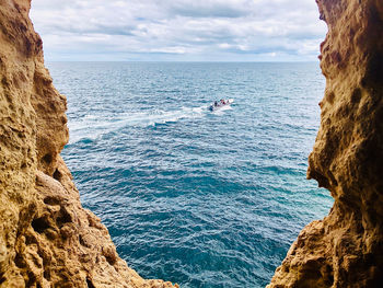View speedboat running in the sea/ocean, view to the ocean from cave, blue sky with fluffy clouds