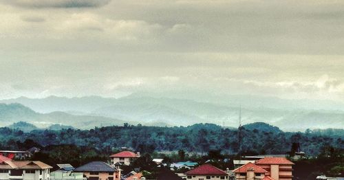 Houses on mountain against sky