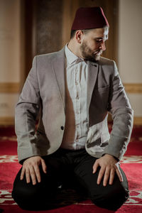 Young man looking away while sitting outdoors