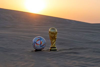 Fifa world cup trophy replica in inland sea qatar with al rihla official match ball of worldcup