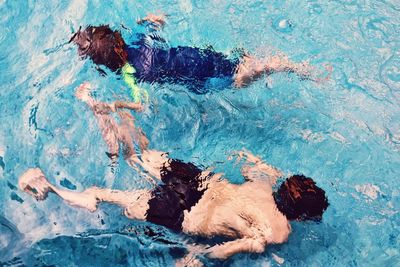 High angle rear view of boys swimming in pool