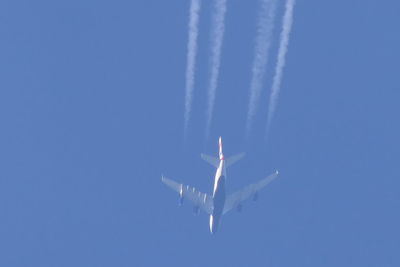 Low angle view of vapor trail against blue sky