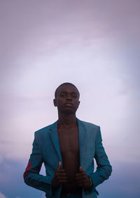 Portrait of young adult standing against clear sky 