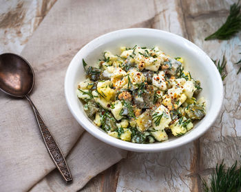 Simple egg and cucumber salad with dill and pepper in a white plate 