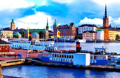 Boats in river against buildings in city