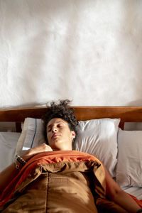 Portrait of young woman sitting on bed at home