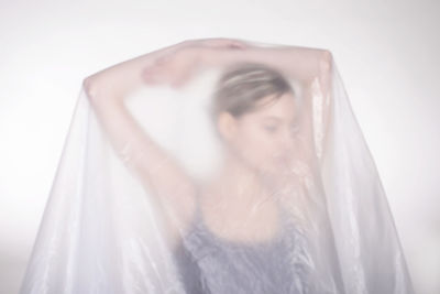 Portrait of beautiful young woman standing against white background