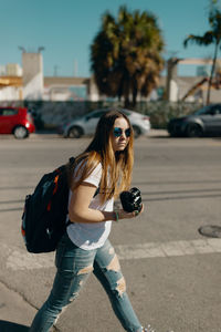 Young woman wearing sunglasses on road in city