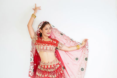 Midsection of young woman standing against white background