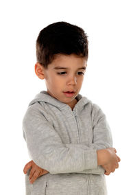 Boy looking away while standing against white background