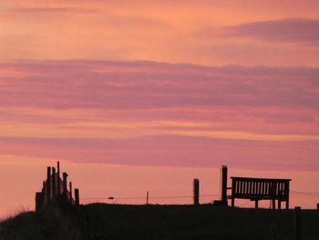 Silhouette of building against cloudy sky during sunset