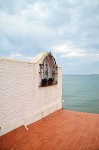 Built structure on beach against cloudy sky