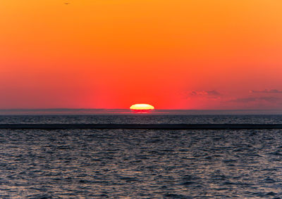 Scenic view of sea against romantic sky at sunset