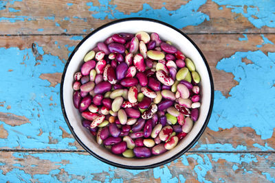 Purple beans background. plate on blue background of many grains of dried beans. brown beans texture