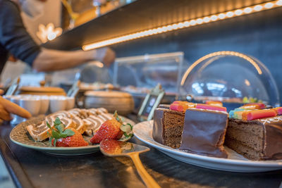 Assortment of fresh sweet cake slices in plate on counter at restaurant