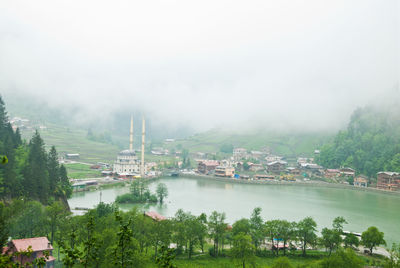 High angle view of buildings by lake against sky