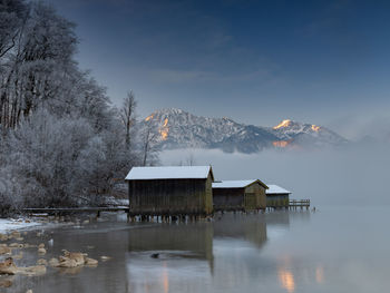 House by buildings against sky during winter