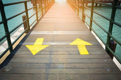 High angle view of arrow sign on wooden floor