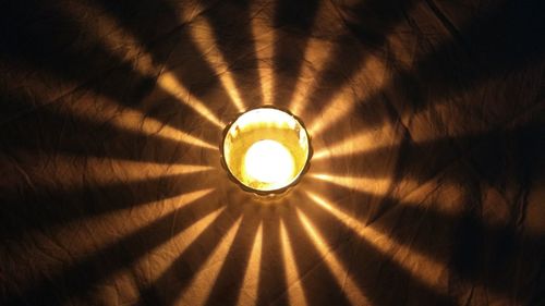 Low angle view of illuminated pendant light hanging from ceiling