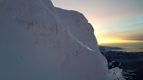 Scenic view of snowcapped mountains against sky during sunset