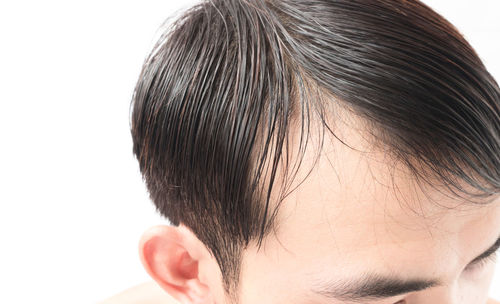 Rear view of shirtless man against white background