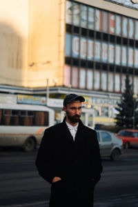 Portrait of young man standing in city