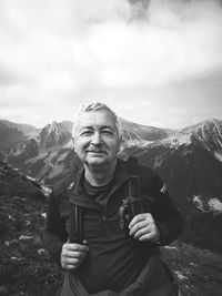 Portrait of smiling man standing on mountain