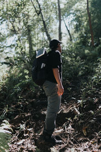 Hiker standing amidst trees at forest