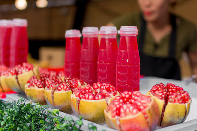 Close-up of fruits and juices for sale at market stall