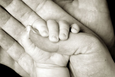 Cropped image of parent holding baby hand