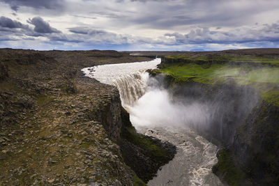 Scenic view of waterfall against sky