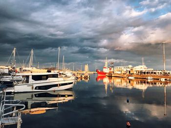 Sailboats moored at harbor