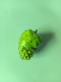 Close-up of green fruit against white background