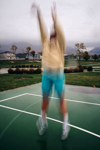 Midsection of man with arms raised against sky