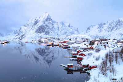 Village by sea against sky during winter