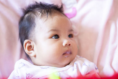 Portrait of cute baby lying on bed