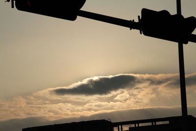 Low angle view of silhouette light against sky at sunset