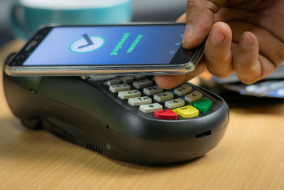 Close-up of person using mobile phone on table