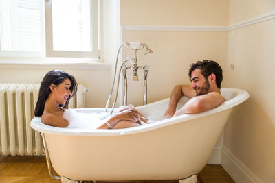 Young couple sitting in bathroom