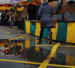 Rear view of man walking on street during rainy season