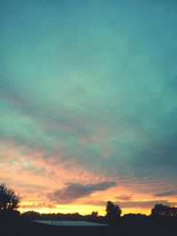 Silhouette of trees against dramatic sky