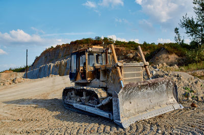 Abandoned vehicle on land against sky