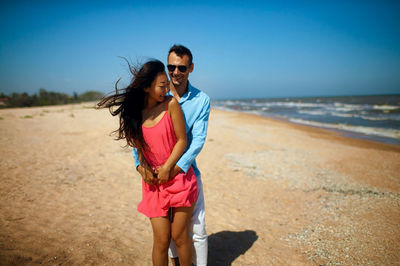 Young couple in love standing at beach