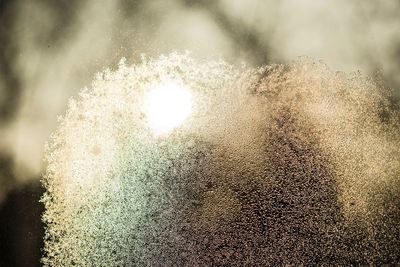 Close-up of raindrops on snow against sky